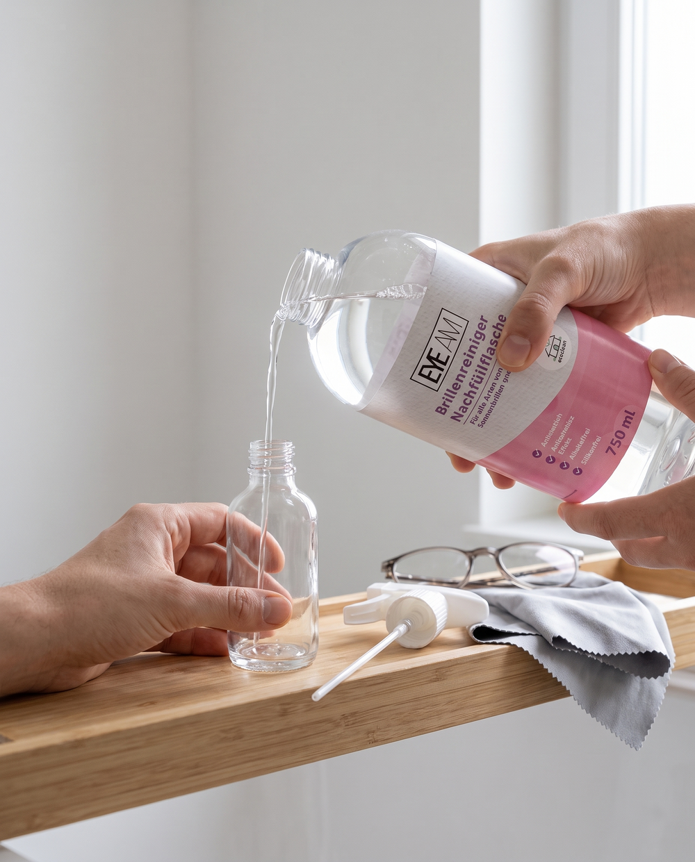 Brillenreiniger Nachfüllflasche: Sprühkopf abgeschraubt, Reiniger wird in die kleine Flasche gefüllt